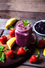 Blueberry smoothies on a wooden background with fruits. Vitamins