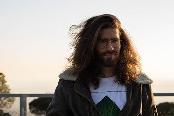 man with long hair wearing glasses