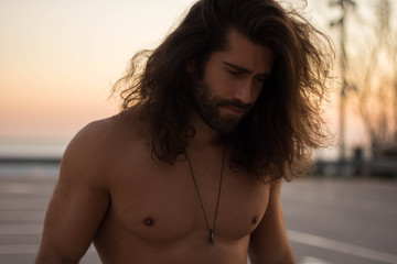 man with long hair looking down