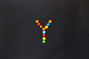 English Alphabet made of colored candies. The letter Y. 