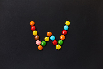 English Alphabet made of colored candies. The letter W. 