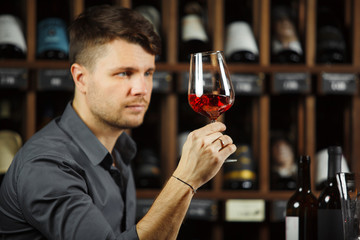Sommelier looking at red wine glass with beverage