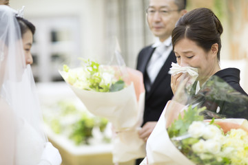 花束を受け取り涙ぐむ母親