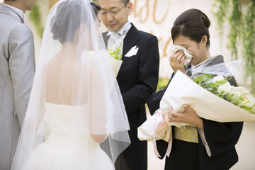 花束を受け取り涙ぐむ母親