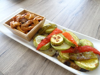 Fried chicken shish kebab on white plate with rustic serving board