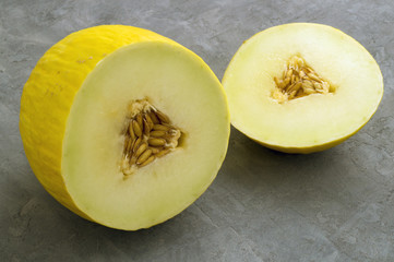 Ripe juicy melon cut. on a gray background.