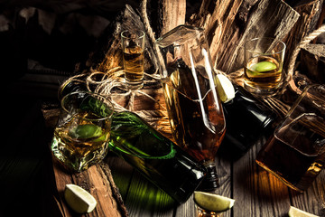 A lot of alcohol, whiskey, tequila, bourbon, brandy, rum on a wooden bar counter, vintage photo