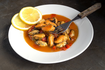 mussels in tomato sauce on a white plate