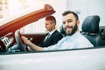 Car of my dream. The guy buying the car in the dealership, the bearded man is sitting with the...