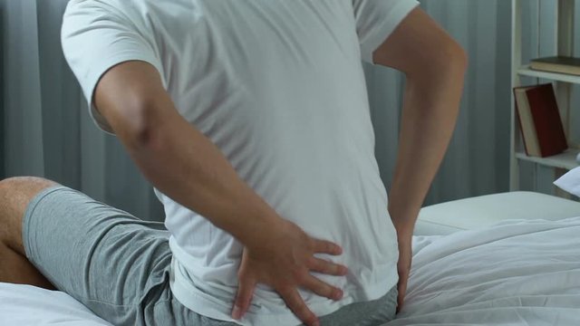 Young male feeling sharp backpain in morning, health care, rheumatism symptom