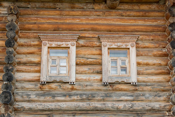 Obraz na płótnie Canvas close up of wooden log house. two windows on the wall