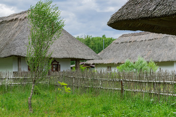 Fototapeta na wymiar Traditional ukrainian rural house with the straw roofs, Ukrainian hamlet