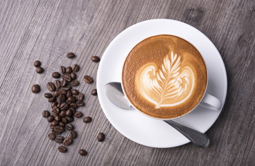 latte or Cappuccino with frothy foam, coffee cup top view on table in cafe.