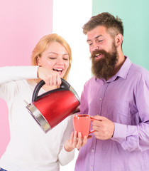 Electric kettle boils water very quickly. Modern devices make our life easier. Prepare favourite drink in minutes. Spending good morning together. Couple prepare morning drink electric kettle device