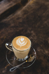 Cup of hot latte art coffee on wooden table