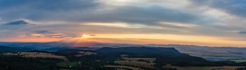 Sunset panorama, inspiring landscape, green forest and mountains