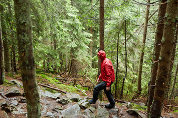 Man with raincoat hiking on a trail