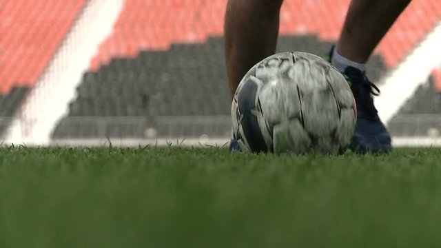 Young soccer player demonstrates footwork by dribbling ball. Slow motion