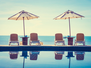Fototapeta premium Umbrella and chair around luxury outdoor swimming pool