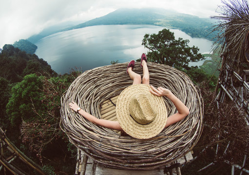 Back view of a young woman in straw hat relaxing looking the landscape. Travelling tour in Asia