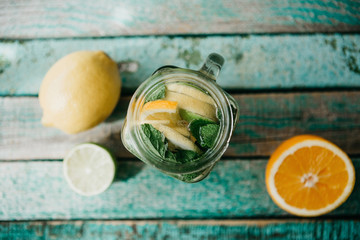 Homemade citrus lemonade or juice or mojito in a jar on a wooden surface. Drink from citrus.