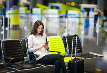 Woman at international airport using a smartphone