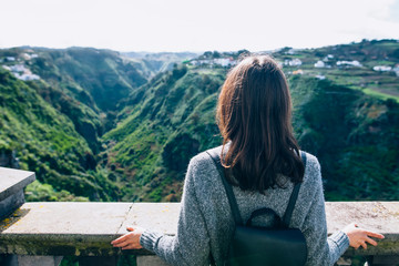Fototapeta na wymiar Back view of traveler woman enjoying beautiful green canyon on Gran Canaria
