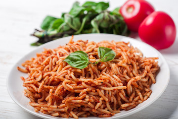 Italian spaghetti with a bolognese tomato meat sauce and basil in a plate. Copy space. Italian food concept.