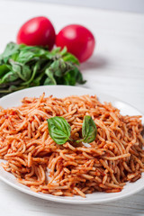 Italian spaghetti with a bolognese tomato meat sauce and basil in a plate. Copy space. Italian food concept.
