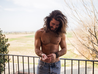 Young man with long hair being in a terrace