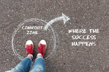 Deurstickers Exit from the comfort zone concept. Feet  standing inside circle comfort zone and outward arrow chalky on the asphalt. © WindyNight