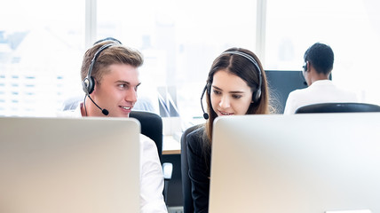 Businessman telemarketing staff working with coworker in call center office