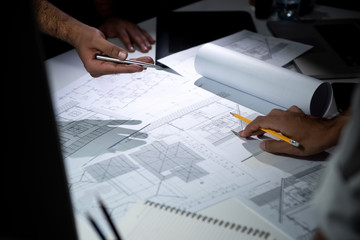 Architect team discussing blueprint paper in office