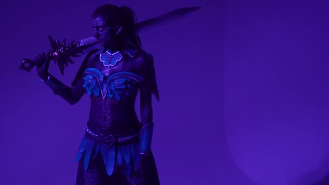 Pompous woman drow posing with a huge fantasy sword and looking away, slow motion