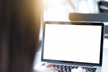 Mockup image of a businesswoman using laptop with blank white desktop screen with coffee cup on wooden table in cafe