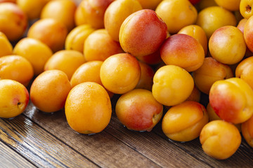 A fresh crop of apricots on an old wooden table.