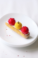 Contemporary Mango Strawberry Eclair, on white background.
