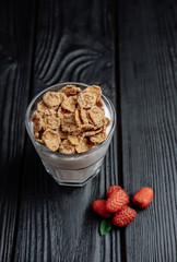 homemade yoghurt with flakes and raspberries on  dark wooden background