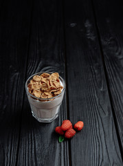 homemade yoghurt with flakes and raspberries on  dark wooden background