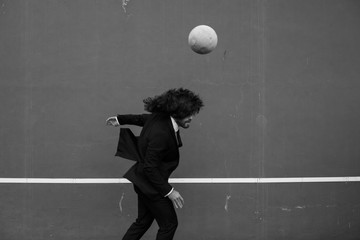 Man wearing a suit hitting the ball