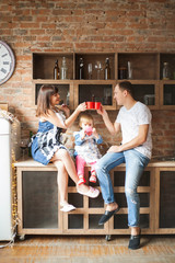 parents and daughter drinking tea in the kitchen