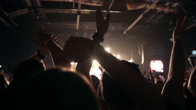 People pulls hands up at a rock concert, slow-motion
