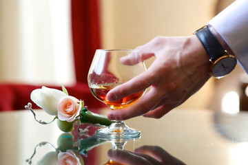 A man's hand holding a glass сup