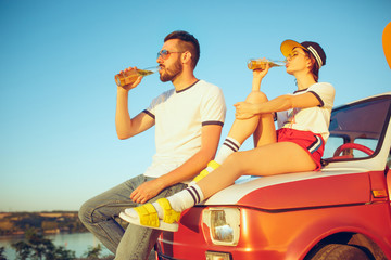 Obraz premium Couple resting on the beach on a summer day near river. Love, happy family, vacation