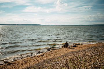 Fisherman on the beach and fisher boat sharing passion