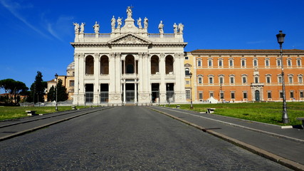 Fototapeta na wymiar Zentralansicht der Laterankirche in Rom mit Statuen auf dem Dach vor stahlblauem Himmel