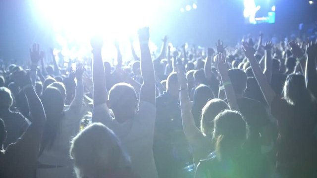 The crowd of shadows of people dancing at the concert, slow-motion