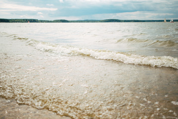 Soft wave of the blue sea on a sandy beach.