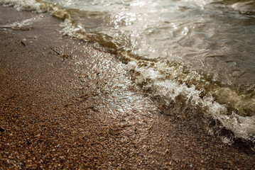 Soft wave of the blue sea on a sandy beach.