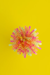 Creative view of drinking straws(neon colors) party on yellow background.